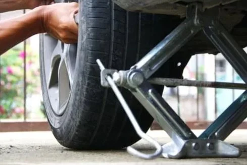 Roadside Assistance technician changing a flat tire